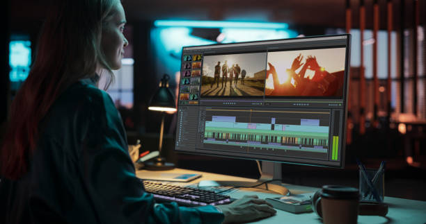 Portrait of Female Videographer Working on a Film on Her Desktop Computer. Focused Woman Making a Video Montage and Design for a Clip in Creative Office at Night